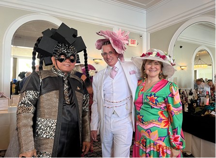 Attendees pose with stylish hats and colorful outfits. 